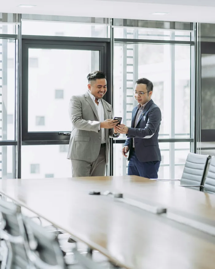 Two consultants in suits talking in a meeting room